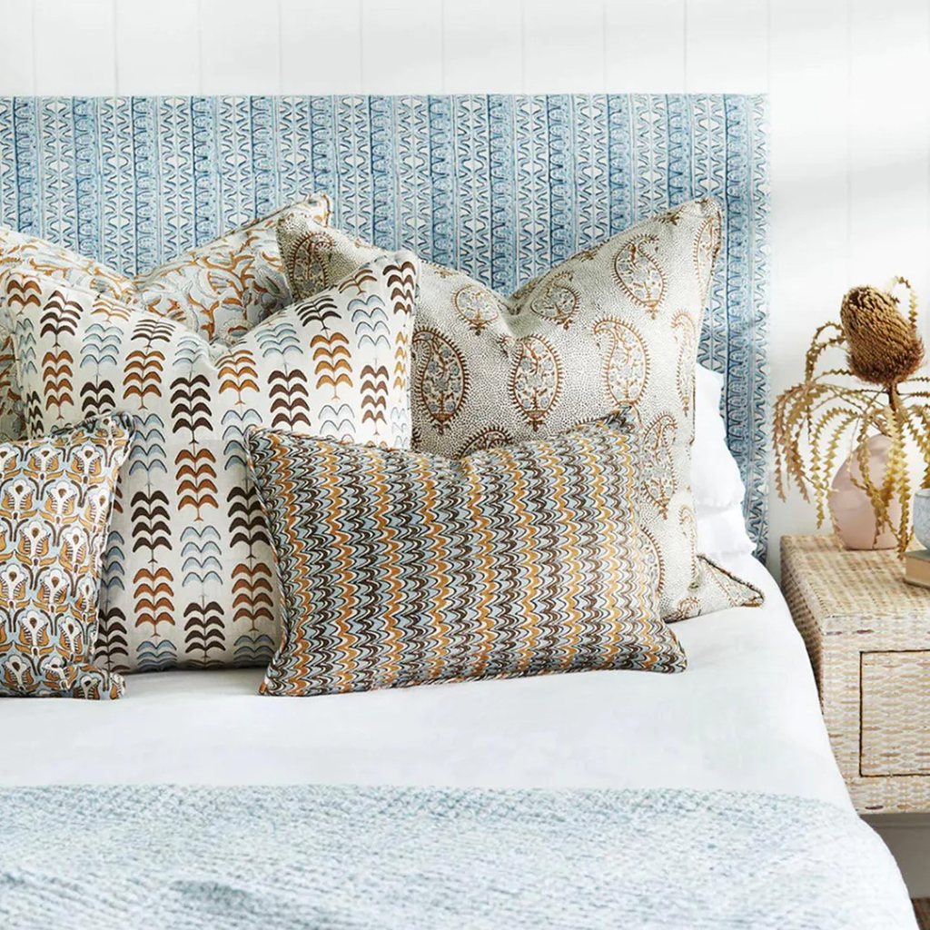 Two beautiful blue and white textured cushions styled on a bed.